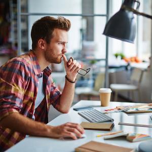 Modern designer sitting in front of computer in office